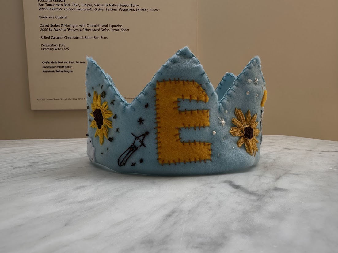 Sky blue felt crown with sunflowers and a golden E