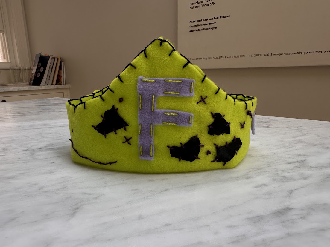 Lime green felt crown with a silver F and bat motifs